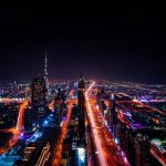 A breathtaking aerial view of Dubai's cityscape at night, highlighting the illuminated Burj Khalifa and surrounding skyscrapers.