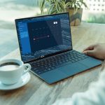 person using black laptop computer on brown wooden table