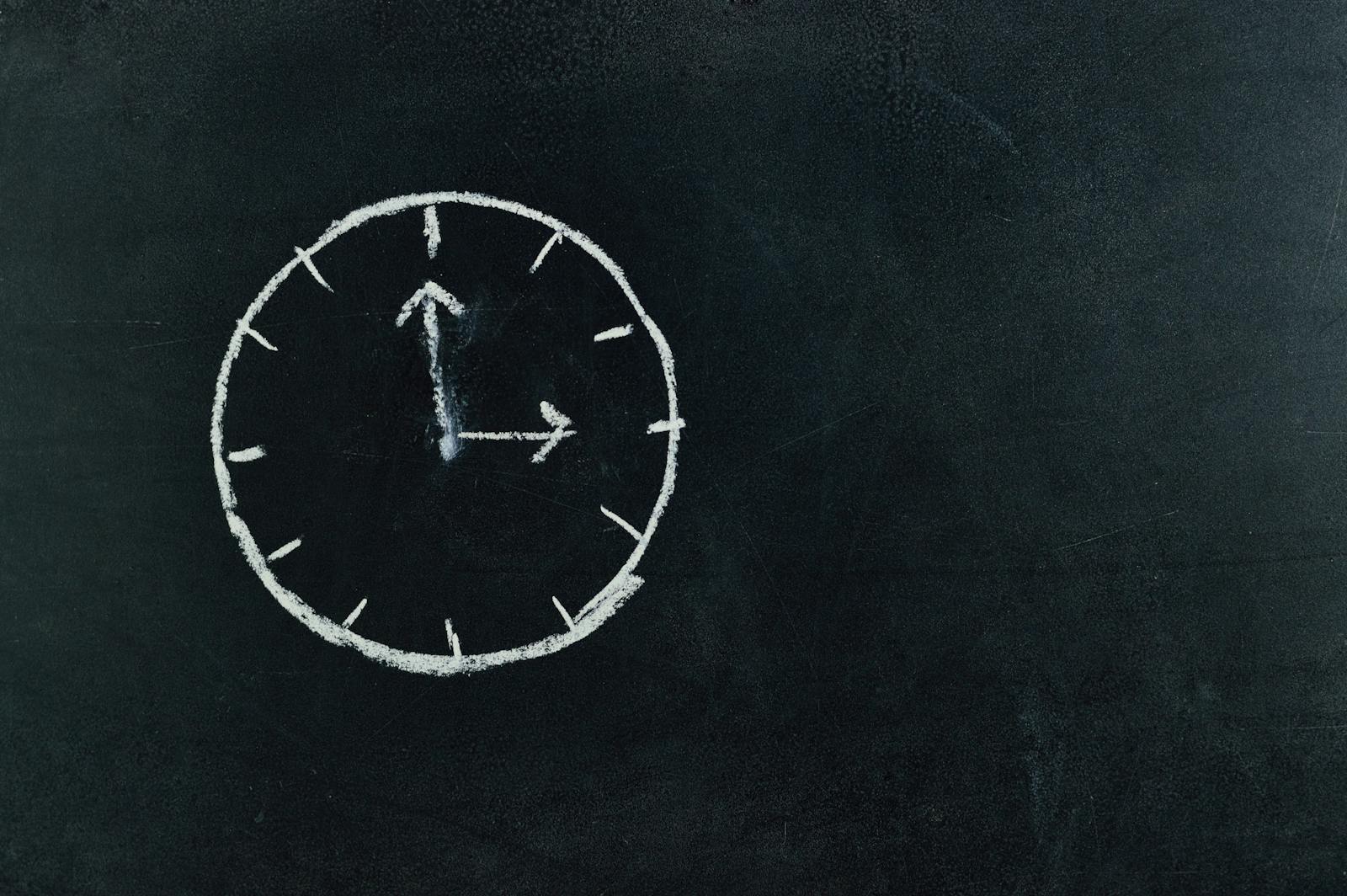 Chalk-drawn clock on a blackboard, symbolizing time and education concepts.