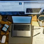 high-angle photography of laptop near calculator, pens, and mouse