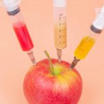 red apple beside clear glass bottle